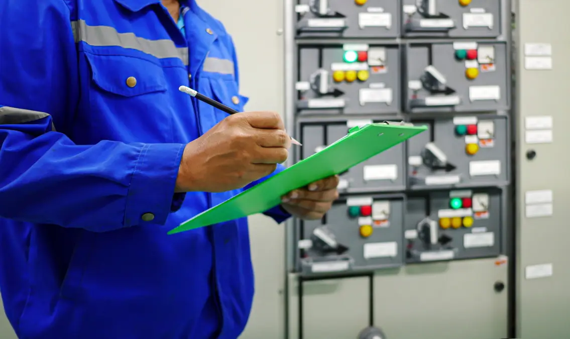 Close-up of an engineer checking items off a list on a clipboard