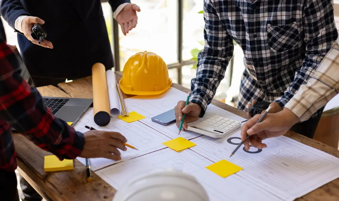 Engineers and architects reviewing blueprints and plans