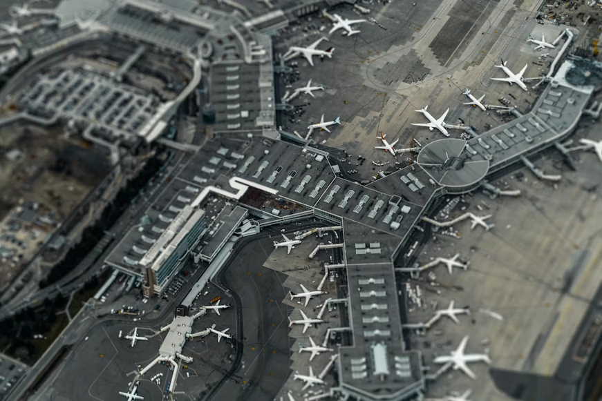 An overhead view of a large airport terminal with multiple airplanes parked at gates