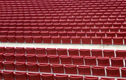 Rows of red stadium seats showing structured seating layout for large sports venue