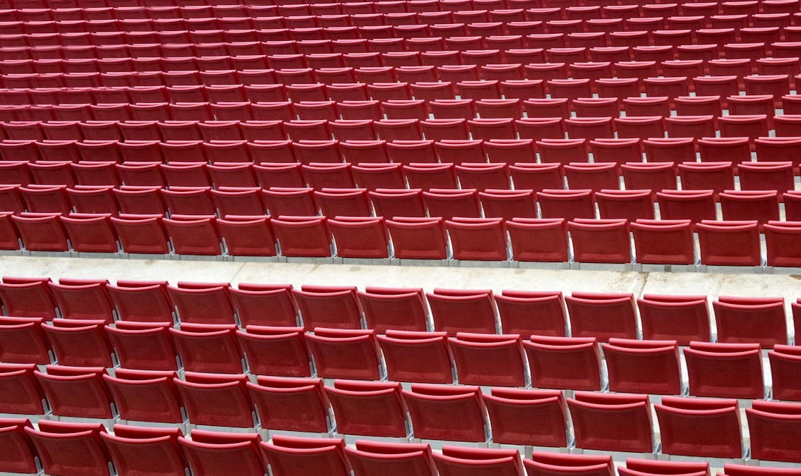 Rows of red stadium seats showing structured seating layout for large sports venue
